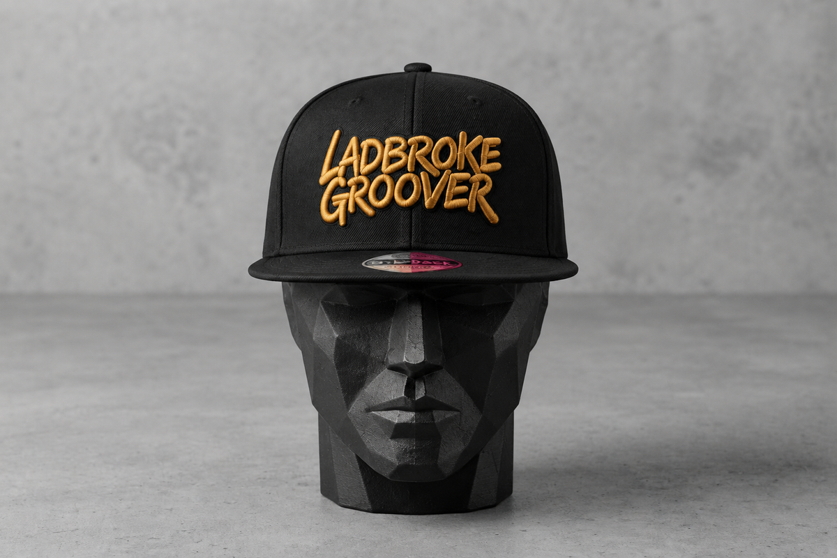 Gold-logo cap facing forward on the black head block