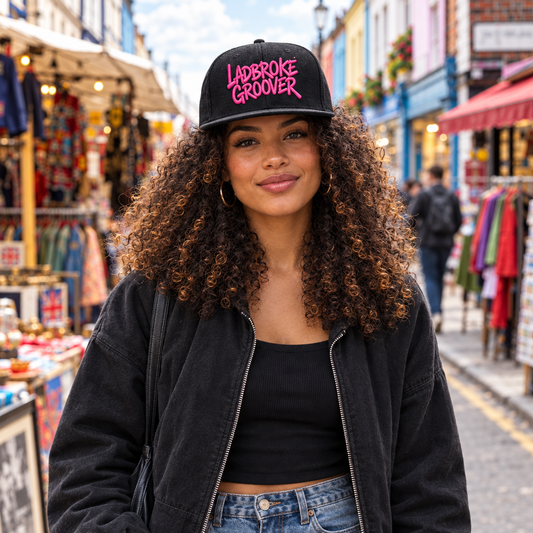 Woman walking on Portobello Road wearing pink-logo cap